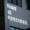 a neon sign that reads time is precious