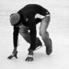A person in a crouched position on ice skates