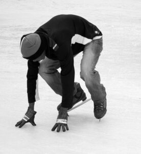 A person in a crouched position on ice skates